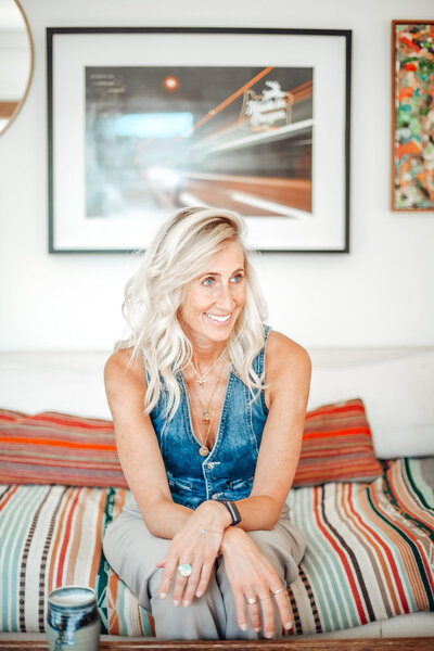 Portland Real estate agent Stephanie smiles and leans forward on a couch. 