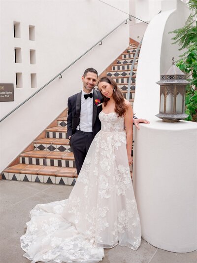 bride and groom poses near the stairs