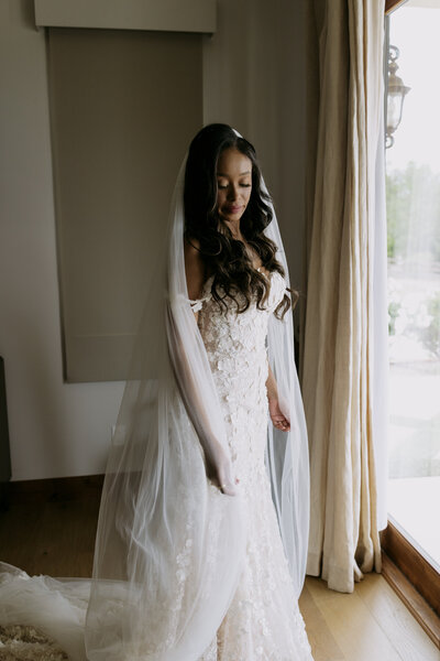 Bride basking the the light coming through the window, soaking in the last few moments before the ceremony.