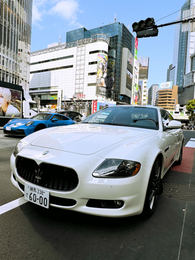 A white Maserati Quattroporte parked near Shibuya Crossing in Tokyo, blending Italian luxury with the iconic energy of Japan’s busiest intersection.