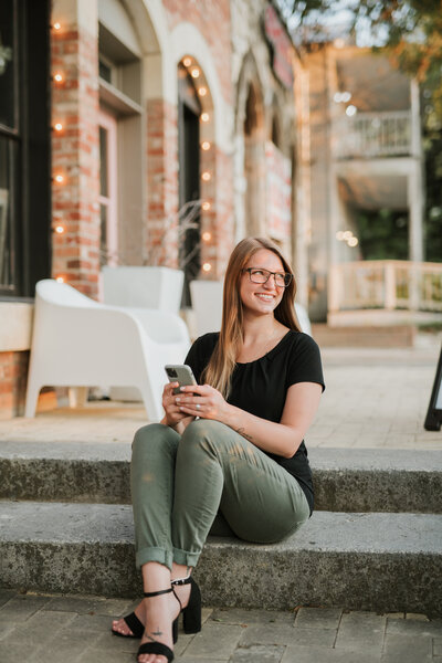 Shawna, owner of Hive and Harmony, walking with a cup of coffee and a laptop in her hands