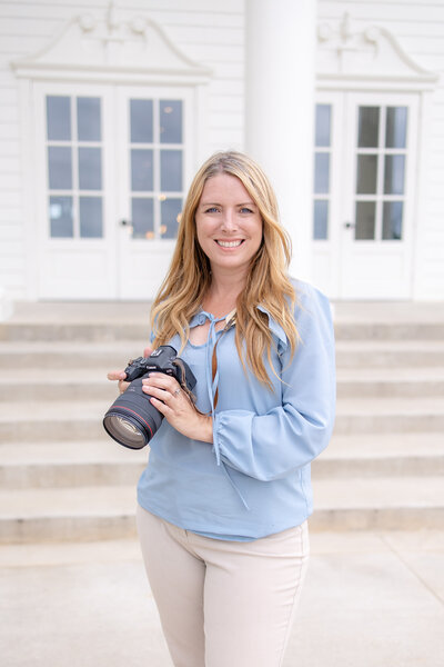 wedding photographer in Texas holds her Canon R6 with L series lens in front of Aubrey Mansion