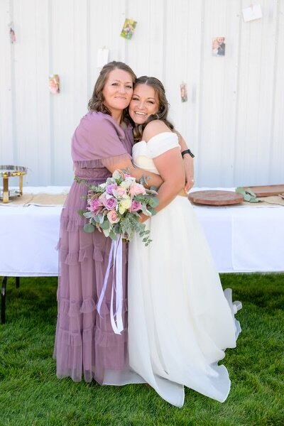 bride with her bridesmaids holding light pink rose bouquets outside the Logan LDS temple