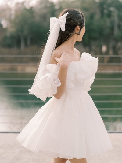 Bride with short poufy dress and large feminine hair bow