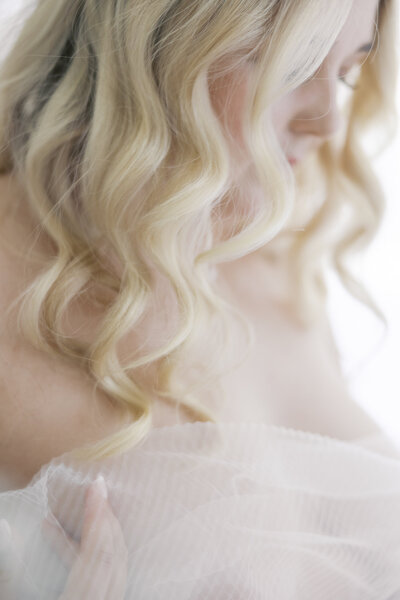 A young woman posing for a bridal boudoir portrait