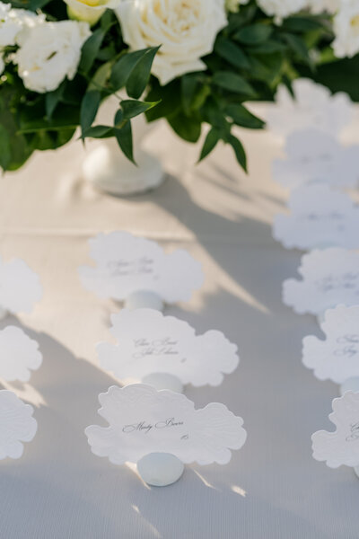 A bright and airy neutral wedding venue photo of the main dining area with brown chairs and white flowers during an alyssa amez design custom wedding