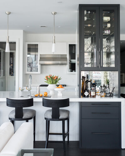 Modern kitchen in a Boston home featuring sleek cabinetry, a marble island, and a stylish built-in home bar area for entertaining.