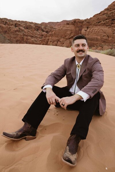 groom smiles during snow canyon red rock elopement