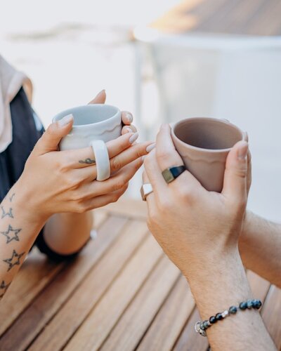 WOMEN WITH STAR TATTOO ON ARM HOLDING CUPS