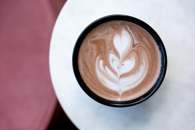 Close-up of a barista pouring heart-shaped latte art at Grain Artisan Bakery & Craft Coffee.