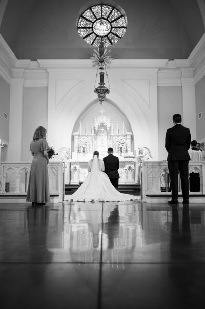 A couple kneel before the altar at their Latin Mass Catholic Wedding in Hampton Roads Virginia, taken by Nathan Sottung Photography