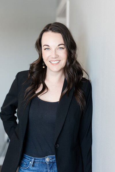 Brea standing next to a wall wearing a black blazer