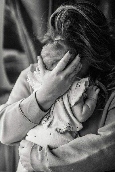 Woman and baby cuddling in black and white