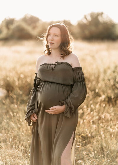 Photo of  a pregnant woman t sunset wearing a red dress