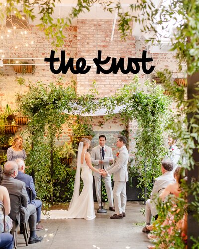 Brooklyn Winery summer wedding, The Knot publication, bride and groom holding hands at the alter at Brooklyn Winery