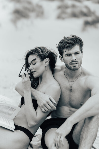 man and woman embracing on the beach