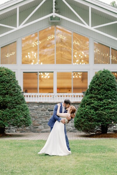 Linnea and Peter kissing in front of their wedding reception venuw
