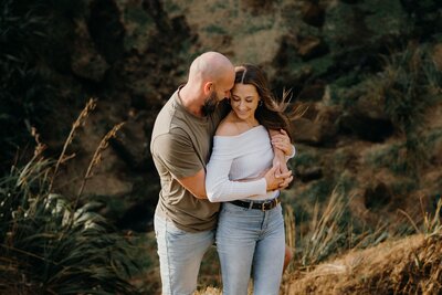 A couple hugging wearing casual clothes during their engagement photoshoot with tashina Narelle in Auckland