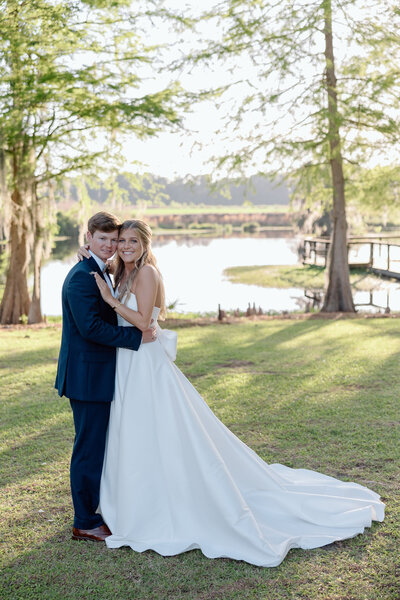 Bride and groom walk hand in hand at sunset