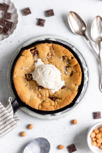 a cookie in a skillet with a scoop of vanilla ice cream on top