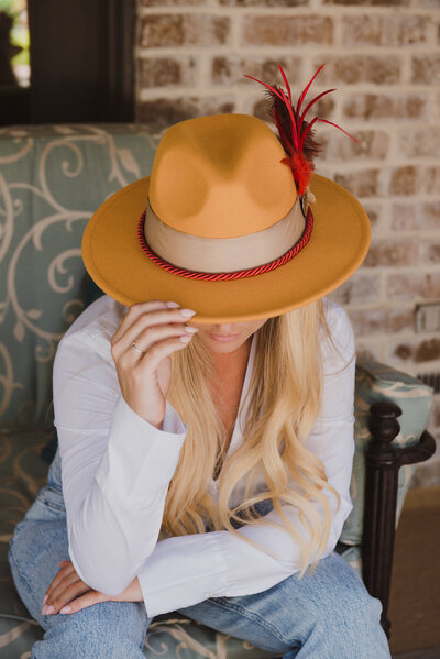Smiling woman in a hat posing inside a vintage green truck with Spanish moss hanging in the background
