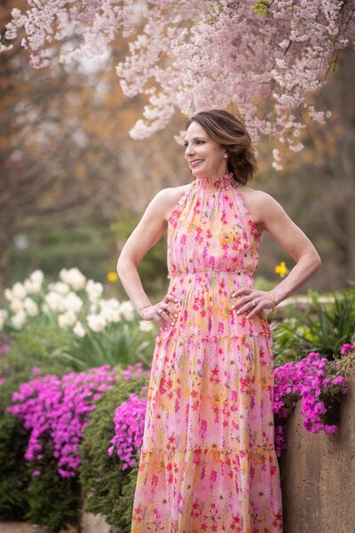 Rebecca standing in front of a blooming apple tree smiling