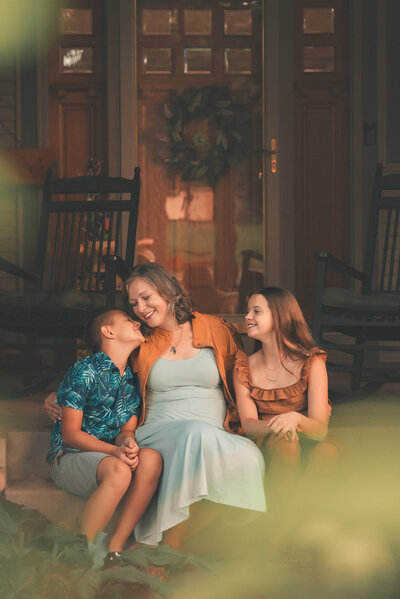 A family posing together outside their home in the Twin Cities, captured in a natural outdoor family photoshoot by Shannon Kathleen Photography, showcasing the warmth of home and family.