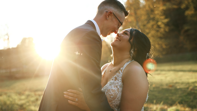 the newlywed couple look at each other with their arms wrapped around one another, with fall leaves and the golden hour sun shining in the background of Brady's Run park after their outdoor october wedding near Pittsburgh, PA