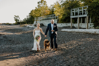 Two Grooms Laughing and Sharing Their Wedding Cake during their Lake Superior Elopement