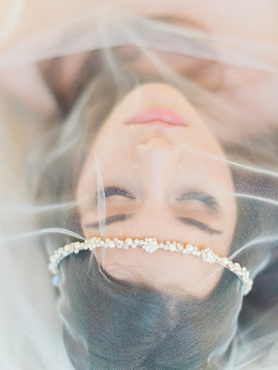 Fine art wedding photography capturing a romantic and dreamy moment of a bride and groom lying on the grass at a luxury wedding in Scottsdale Arizona.