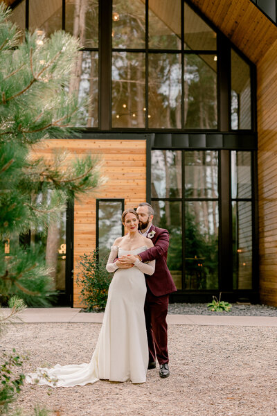 Bride and groom embrace in front of an elegant building