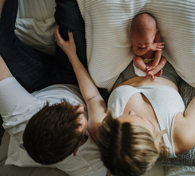 New parents holding newborn in nursery at home for lifestyle newborn shoot