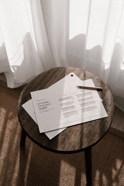 Flat lay of brand strategy documents and creative direction guide on a wooden table, part of the Moonstone Brand Star Chart process.