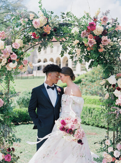 Malibu wedding photo of bride and groom surrounded by floral arch