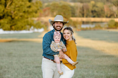 Family portrait of mom and dad holding  baby during family photo session at El Cerrito Lodge in New Diana, TX