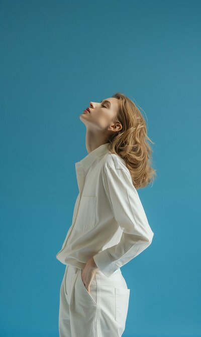 woman with her head towards the sky with her eyes closed on a blue background