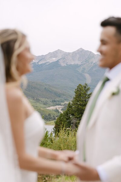 Bride and groom holding hands with mountain views at Sapphire Point Overlook in Breckenridge, Colorado