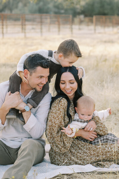 A family shares some laughter together at their fall family photos