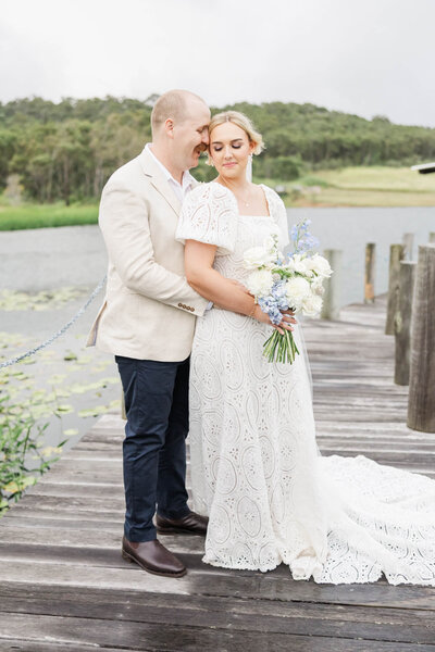 Bride and groom sharing a quiet moment together on a jetty at the wedding venue The Salty Lime, located near Yeppoon, Queensland