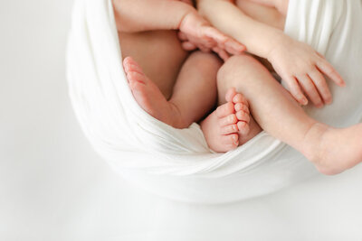 twin newborn baby feet captured sweetly in this photographer session in Omaha Nebraska