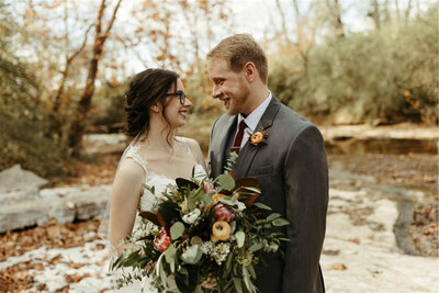 couple looking at one another while standing in a creek bed