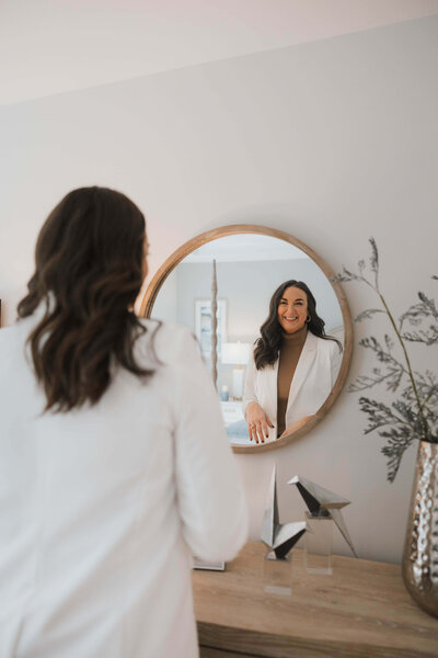 Steph Wagner Wilmington Realtor for Jacie and Co looking in mirror in modern Wilmington house for sale.