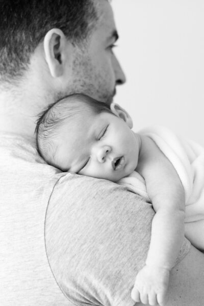 Black and white pjhoto of newborn and daddy