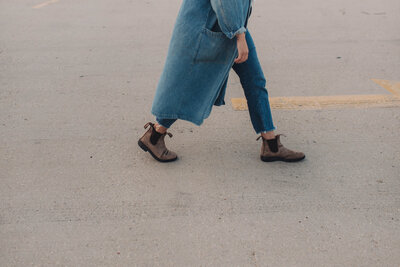 Waist down photo of Marisa of Msav Creative Co in a denim jacket walking along a parking garage