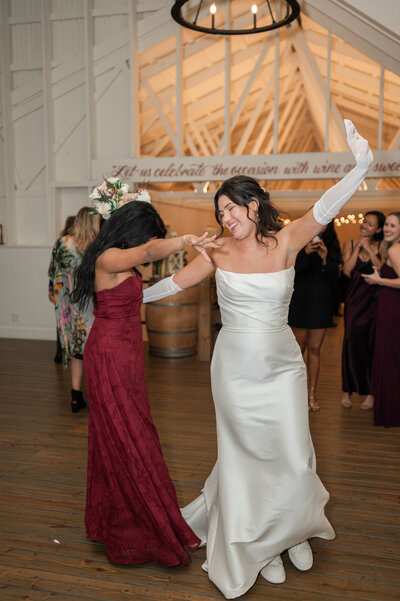 A bride dancing with a wedding guest at a reception
