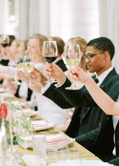 : Guests raising glasses during estate dinner – Multi-Day Wedding Photographer