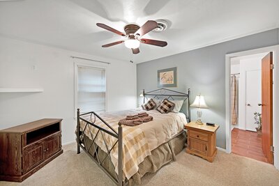 Master bedroom with private bathroom in this 3-bedroom, 2-bathroom vacation rental home with large fenced yard, firepit, and dock access with incredible views of Lake Whitney.
