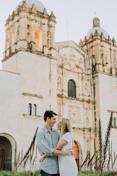 couple holding each other in front of a church