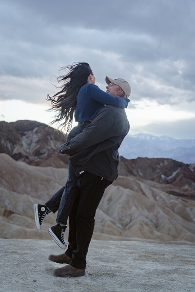 A person holding their partner up and smiling