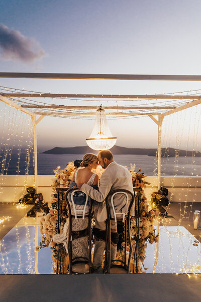 bride and groom at sunset in Santorini under fairy lights